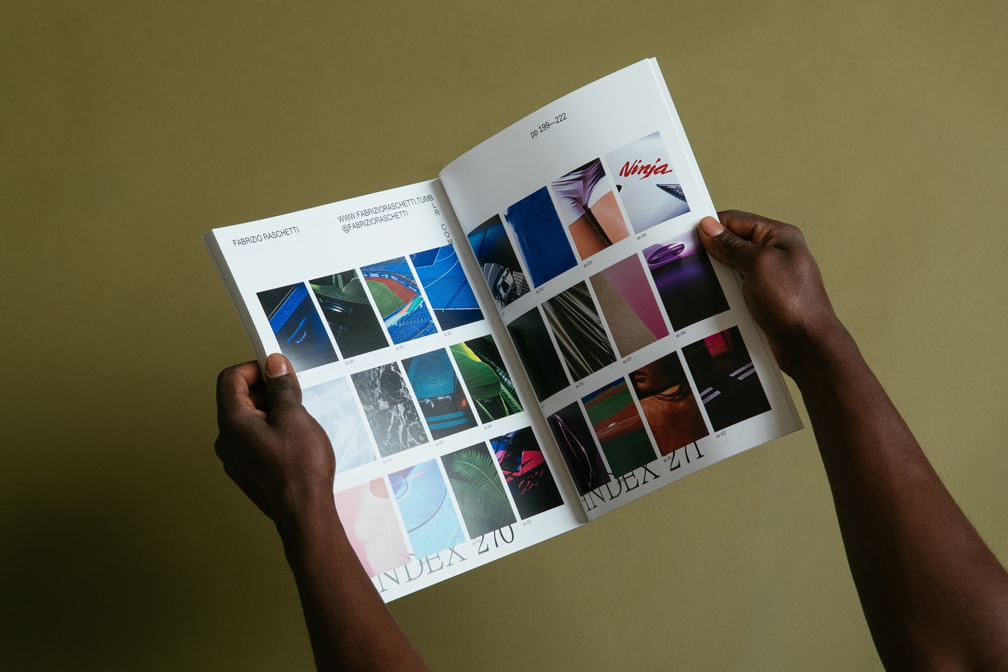 Someone holds a magazine open to a page of images in a grid.